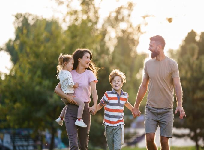 Family of 4 laughing and holding hands
