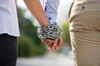 Couple's hands tied with metal chain